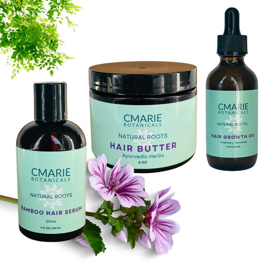 "Image of CMarie Botanicals Triple Threat Hair Care Set featuring Bamboo Hair Serum (Shine), Herbal Infusion Hair Butter (Ayurvedic Herbs), and Hair Growth Oil (Rosemary + Horsetail). A natural, botanical-themed arrangement includes fresh greenery and purple flowers, emphasizing the set’s organic and nourishing qualities."